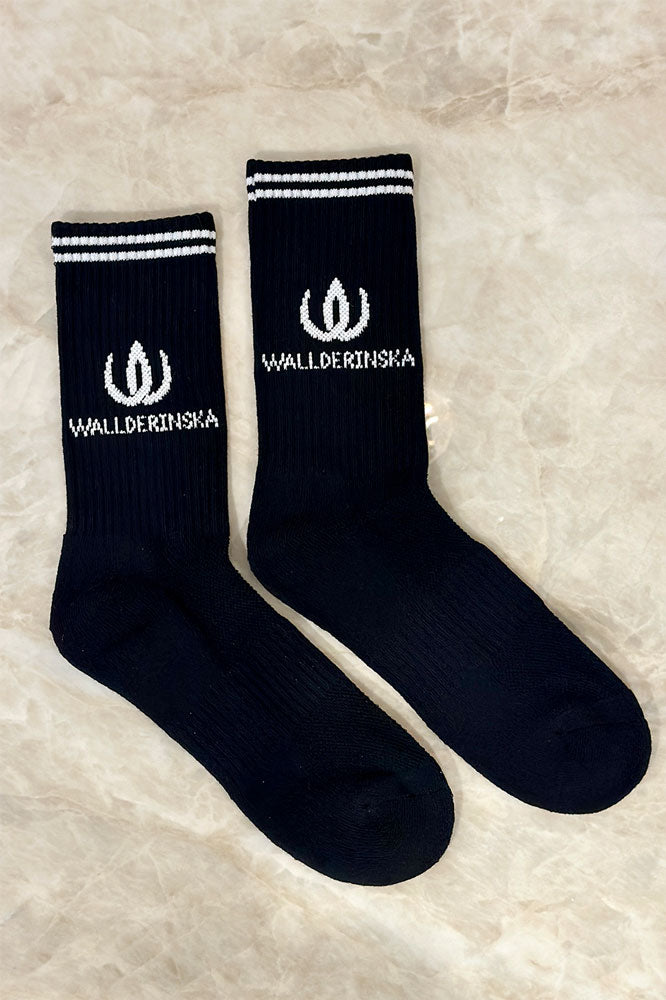 W-Crew Sock Black på fot i studiomiljö